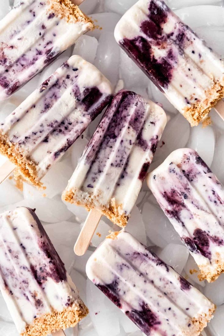 several popsicles with blueberry toppings sitting on ice