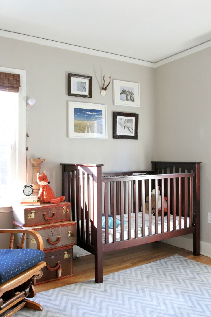 a baby's room with a crib, dresser and pictures on the wall