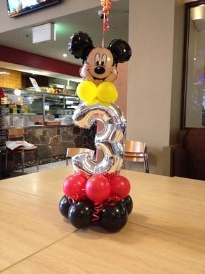 a mickey mouse balloon sculpture with the number 3 on it