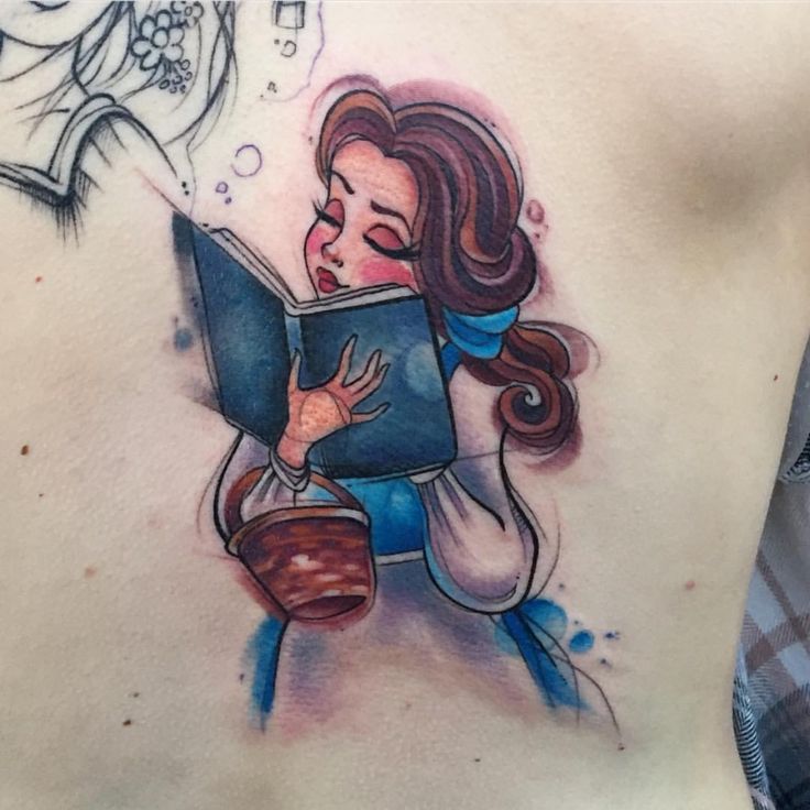 a woman with a book tattoo on her stomach is looking at a bird flying in the sky