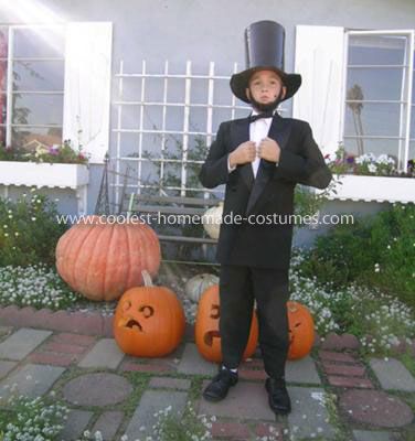 a young boy in a tuxedo and top hat standing next to pumpkins