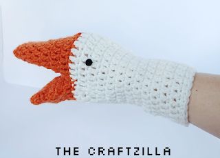 an orange and white knitted bird is shown in the palm of someone's hand