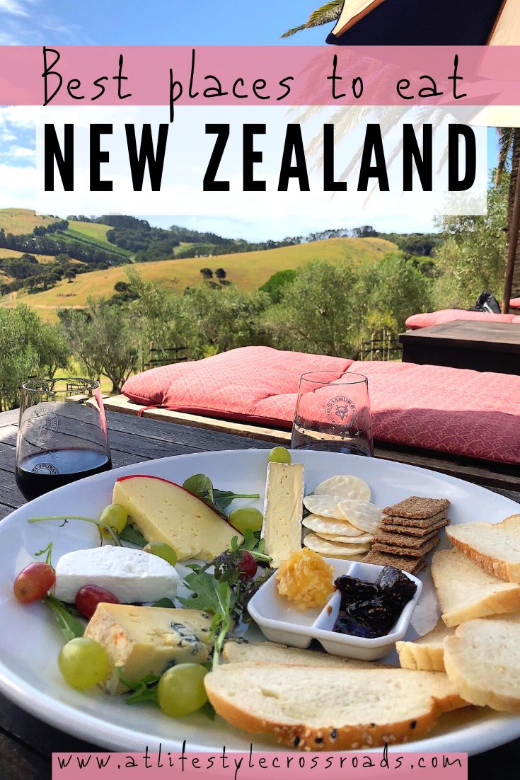 a white plate topped with bread and cheese next to a glass of wine