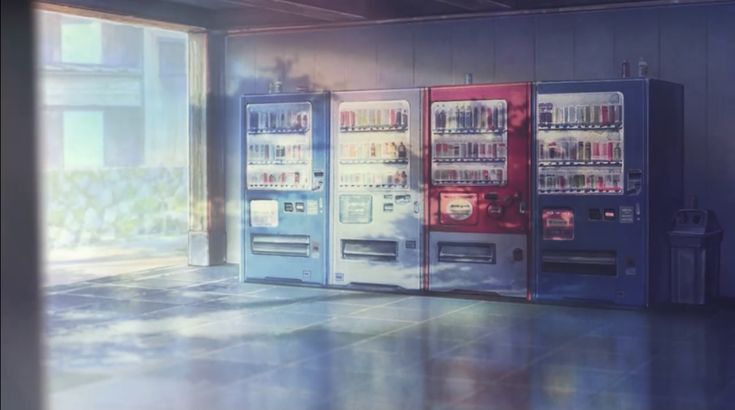 three vending machines are lined up against the wall in an empty room with large windows