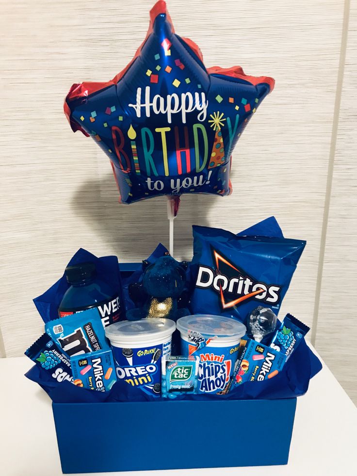 a birthday gift box filled with snacks and balloons