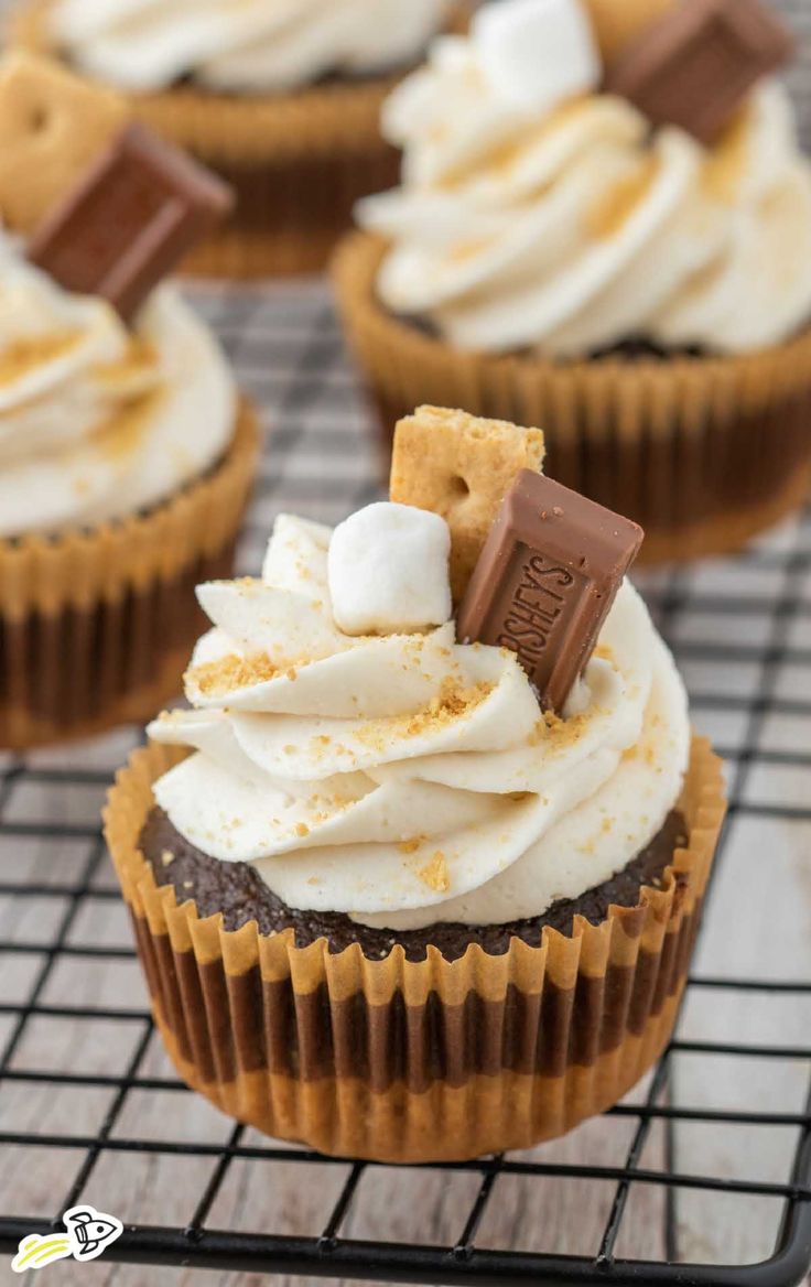 cupcakes with marshmallows and graham crackers are on a cooling rack