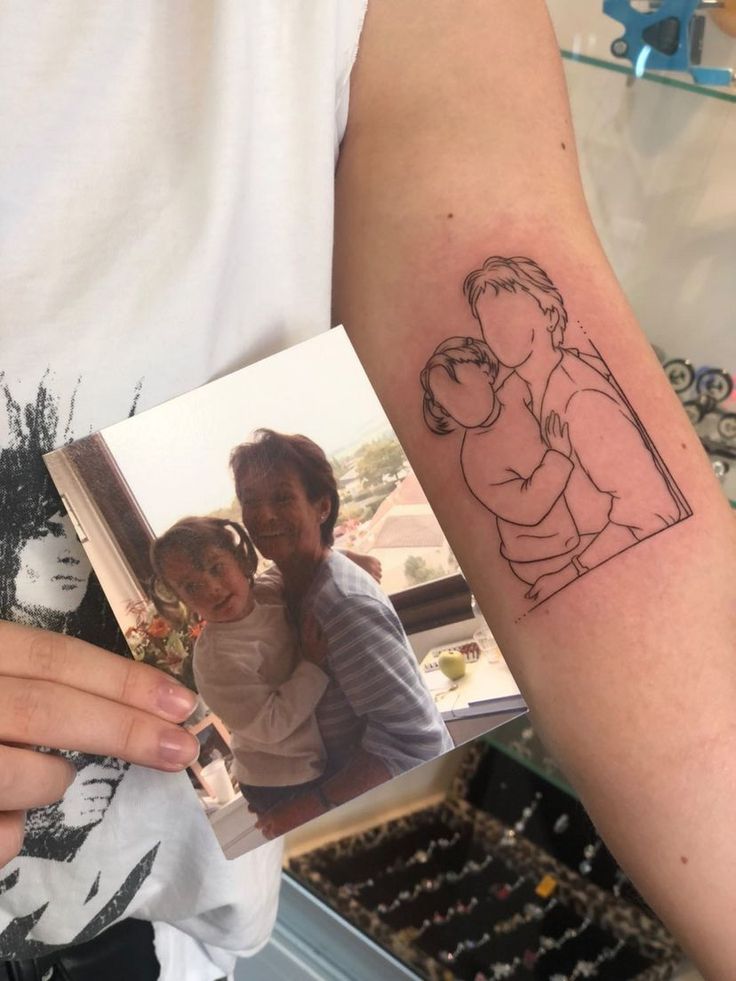 a person with a tattoo on their arm holding up a book and an image of a man