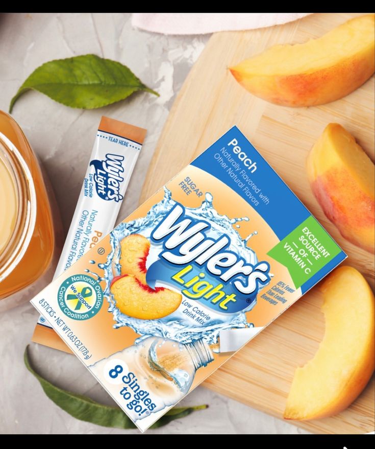 a box of juice next to sliced peaches on a cutting board