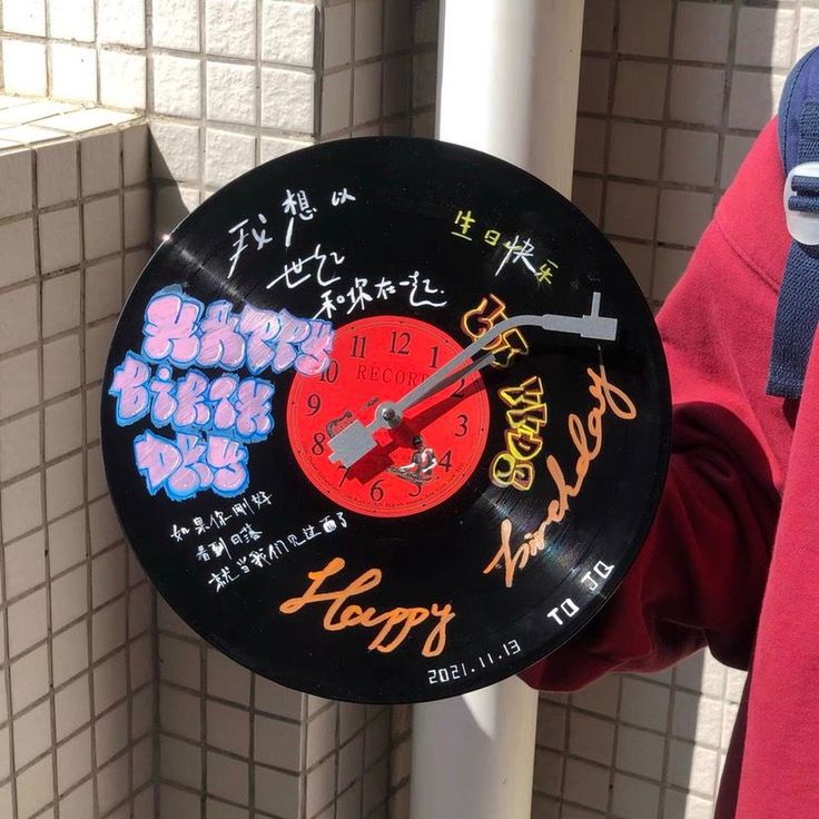 a person holding a clock with writing on it