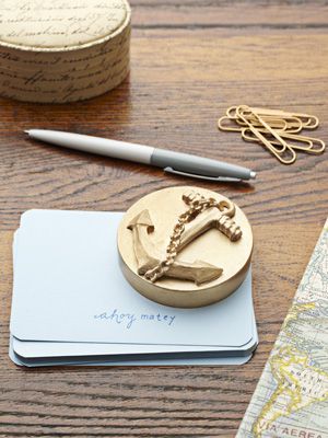 a wooden stamp sitting on top of a table next to a pen and some paper