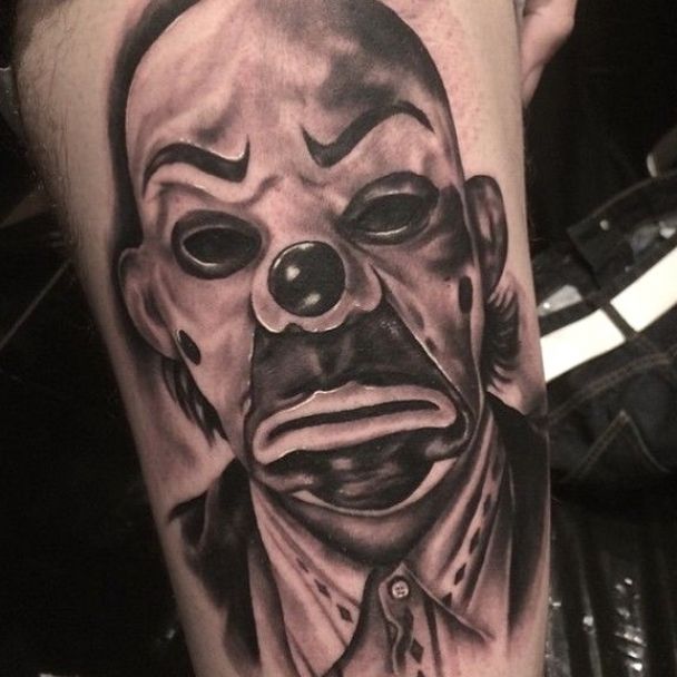 a man's leg with a tattoo of a creepy clown on it and his face