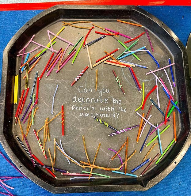 a metal tray filled with lots of different colored pencils and writing on the side