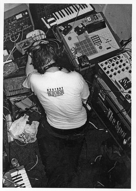 a man sitting in front of an electronic keyboard and mixing equipment with headphones on