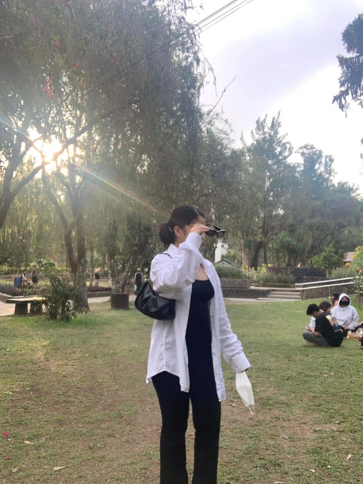 a woman is standing in the grass taking pictures