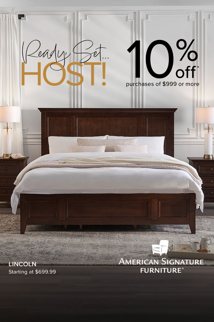 a bed with white sheets and pillows in front of an advertisement for the american signature furniture store