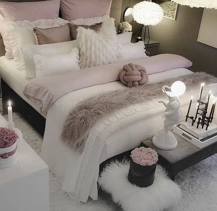 a bedroom with black walls and white fur rugs on the floor, two lamps above the bed