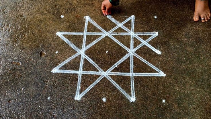 an artistic drawing on the ground with white lines and dots around it, which are shaped like a star