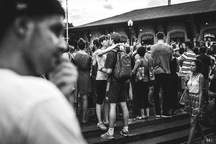 black and white photograph of people standing on the steps in front of a train station