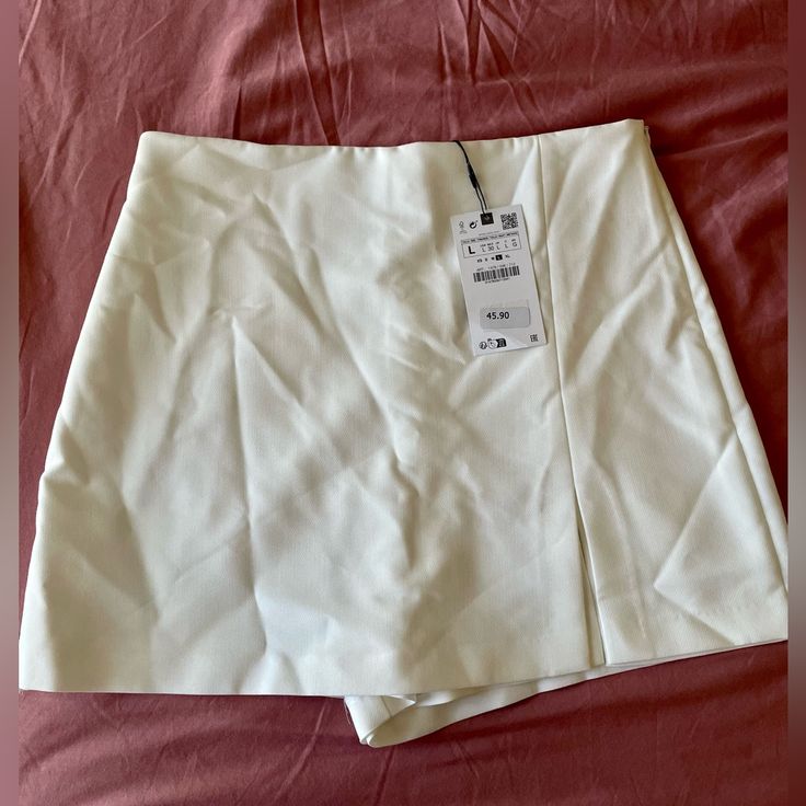 This Zara Skort (Skirt With Shorts) Is New With Tags And Comes In A Beautiful Shade Of White. It Is A Very Versatile Piece, As It Can Be Used In Hotter Weather Or Paired With A Sweater During The Upcoming Fall/Winter Months. It Is Marked A Size Large And Has A Zip Closure. Summer Skirts With Built-in Shorts, Skirt Bottoms With Built-in Shorts For Day Out, Day Out Skirt With Built-in Shorts, Skirt With Built-in Shorts For Day Out, White Skirt Bottoms With Built-in Shorts, White High Waist Shorts With Lined Skirt, Elegant Short Mini Skirt For Spring, Elegant Short Skort For Summer, Elegant Short Skort For Day Out