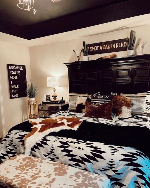 a bed room with a neatly made bed and a cowhide rug on the floor