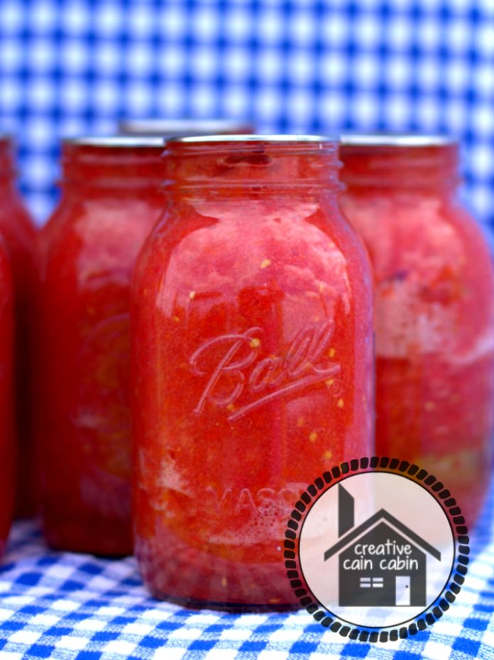 three jars filled with red liquid sitting on top of a blue and white checkered table cloth