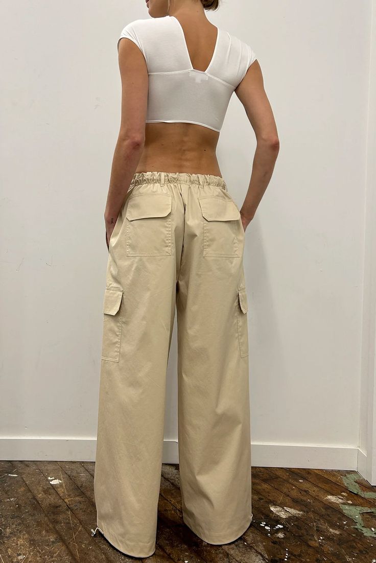 Oversized cargo pant with an elasticized waist, six patch pockets, belt loops, and adjustable toggles at the hem so the wearer can adjust the hem opening as desired. Fit runs true to size Pulls on Made from lightweight stretch fabric Adjustable gathered waist and leg Composition: 68% Cotton, 28% Polyester, 4% Elastane Made in Portugal Khaki Utility Cargo Jeans With Elastic Waistband, Utility Wide-leg Cargo Pants With Elastic Waistband, Khaki Utility Parachute Pants With Loose Fit, Utility Wide Leg Cargo Pants With Elastic Waistband, Beige Wide Leg Cargo Pants With Cargo Pockets, Solid Utility Parachute Pants With Patch Pockets, High Waist Beige Cargo Pants With Cargo Pockets, Beige Baggy Bottoms With Cargo Pockets, High-waisted Beige Cargo Pants