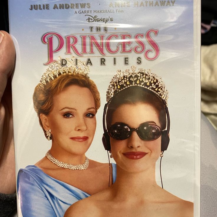 someone holding up a dvd cover for the princesses diaperies, which features two women wearing tiaras