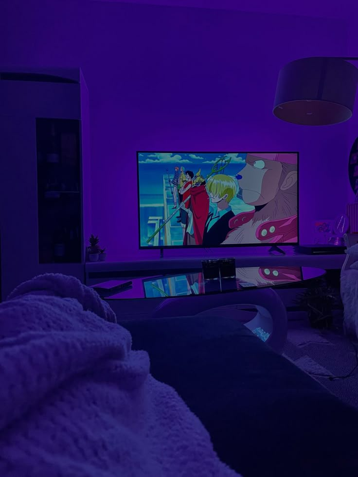 a person sitting in front of a tv with purple lighting