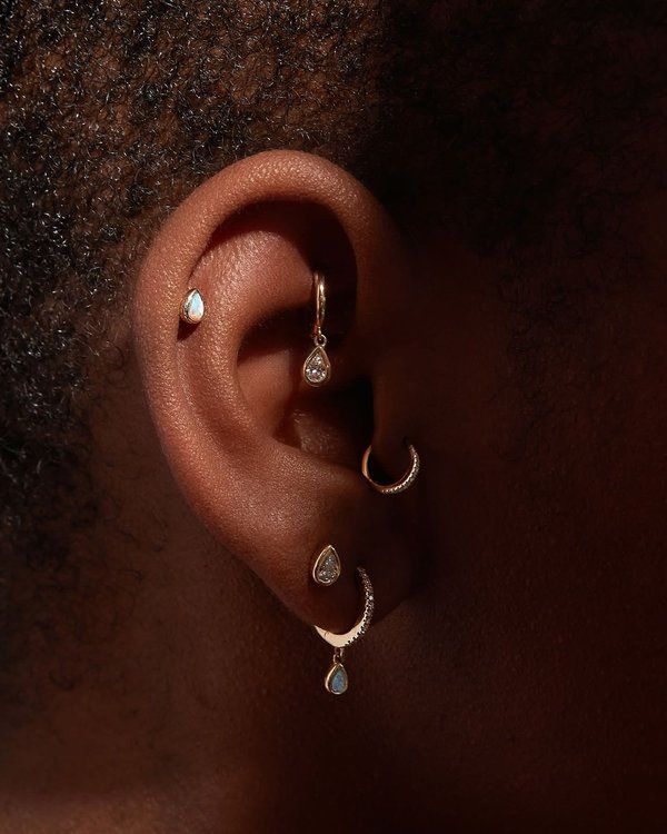 a woman's ear is shown with two small white stones