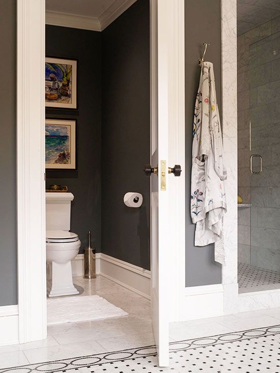 an open door leading to a bathroom with gray walls and white trim on the doors