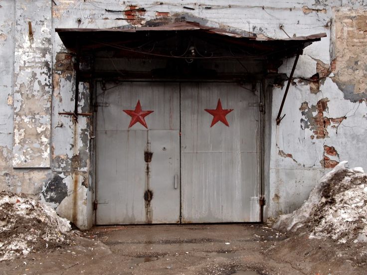 an old building with two red stars painted on the doors