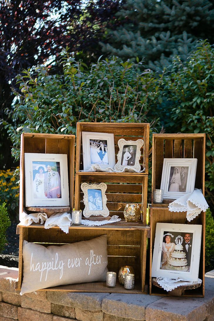 an outdoor display with pictures, candles and other items on the side of a brick wall