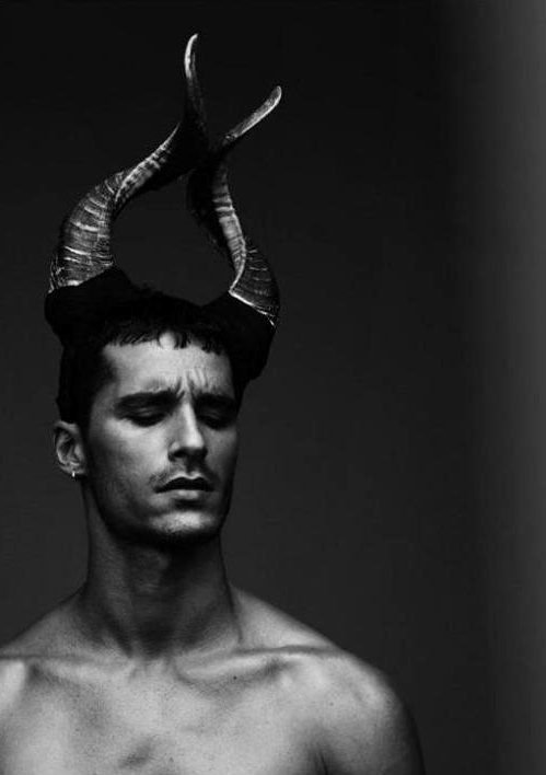 a shirtless man with horns on his head