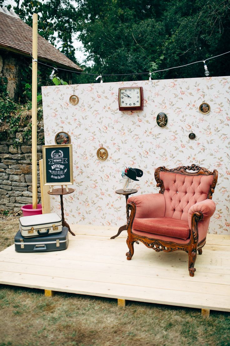 an old chair sitting on top of a wooden platform in front of a white wall