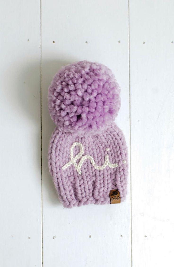 a purple knitted hat hanging on the wall