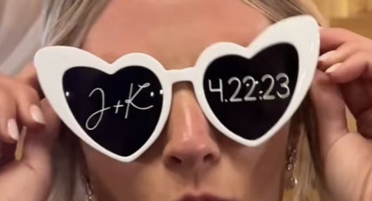 a woman holding up two heart shaped sunglasses with the words k - 5223 written on them