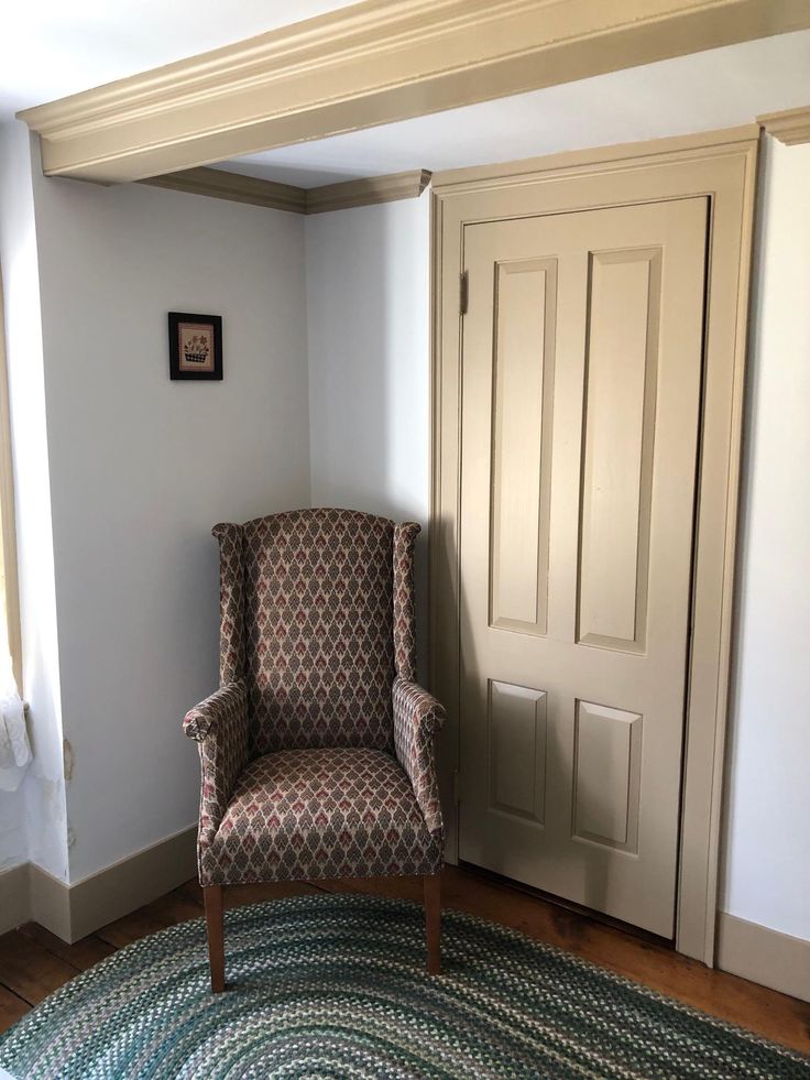 a chair sitting on top of a wooden floor next to a white door in a room