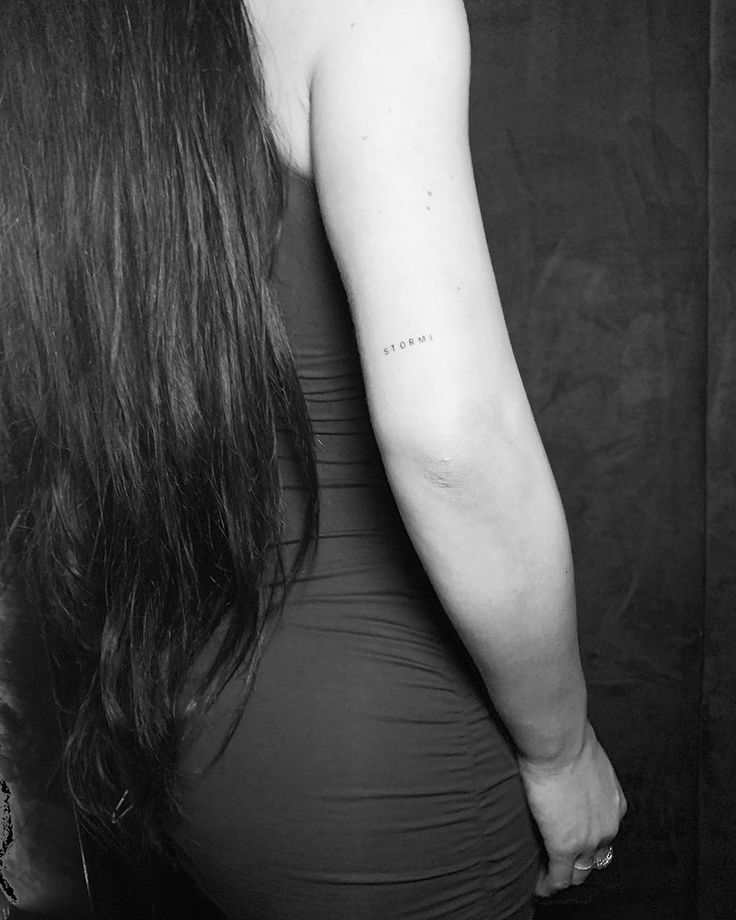 the back of a woman's left arm with a tattoo on her right arm