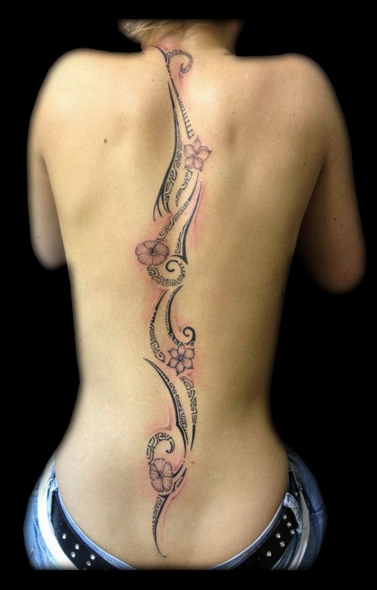 the back of a woman's body with tattoos on her lower and upper back