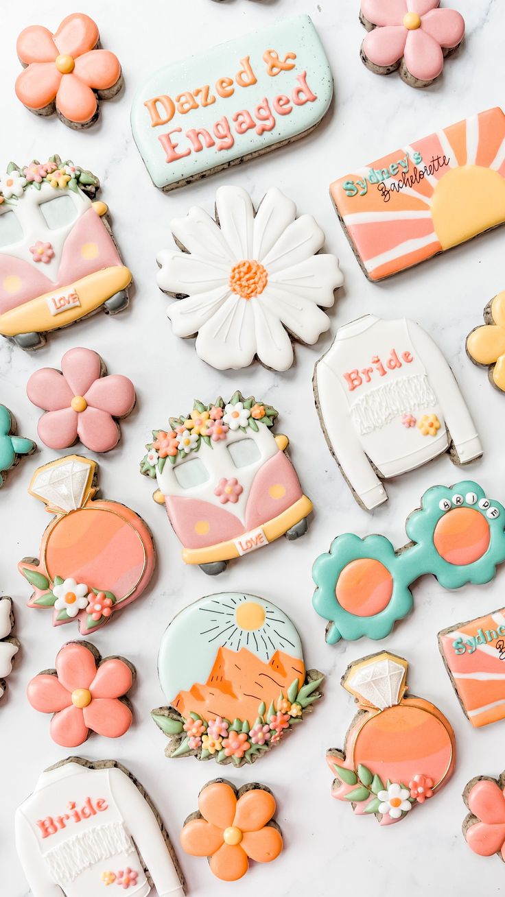 some decorated cookies are laying out on the counter top with flowers and other decorations around them