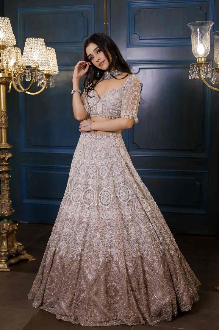 Ombre Ivory and champagne lehenga with all over pearl, sequin, crystal and cutdana work. Paired with a statement sweetheart neck blouse with tassel hangings and embroidered scallop dupatta.From Isa by Dolly Wahal's Fiori collection.DELIVERY TIMEPlease allow 8-12 weeks for your outfit to arrive.FABRIC DETAILSNetProfessional cleaning only. Champagne Lehenga, Scallop Dupatta, Sweetheart Neck Blouse, Cutdana Work, Sweetheart Neck, Skirt Length, Lehenga, Light Box, Sequin