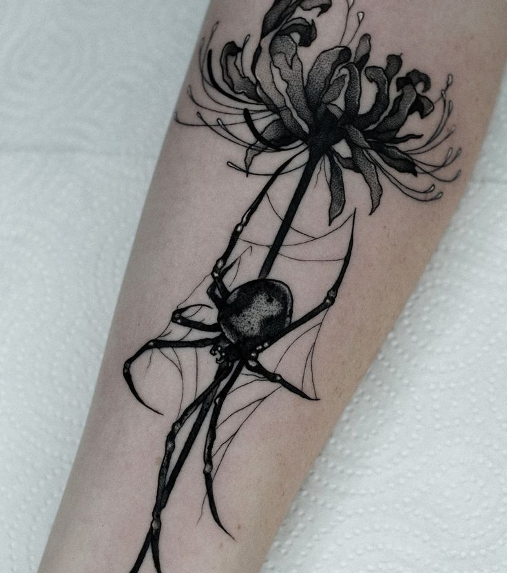 a black and white photo of a spider with flowers on it's leg,