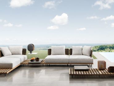 a living room with couches and tables in front of a large window overlooking the countryside