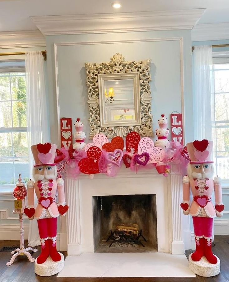 two nutcrackers are standing in front of a fireplace decorated with pink and red decorations