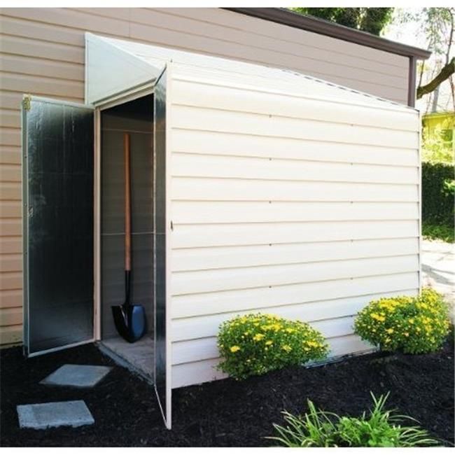 an outhouse with the door open and some flowers in the ground next to it