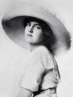 an old black and white photo of a woman wearing a large hat with her hands on her hips