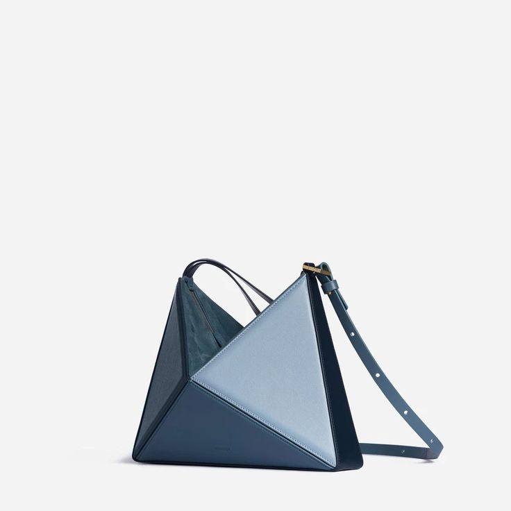 Our architectural, origami inspired shoulder bag, now has a new dimension. It can be converted into a wrist bag just with a quick move. The shoulder strap can easily be removed, so you can slung it from your wrist or use as a clutch. It has plenty of room inside for your essentials including a large phone, small wallet Modern Bucket Bag With Top Carry Handle For Gift, Modern Blue Box Bag With Dust Bag, Square Bucket Bag With Dust Bag As Gift, Modern Square Bucket Bag As Gift, Designer Shoulder Bag With Handle Drop As Gift, Modern Handheld Blue Shoulder Bag, Modern Blue Handheld Shoulder Bag, Modern Double Handle Box Bag As Gift, Modern Double Handle Box Bag For Gift