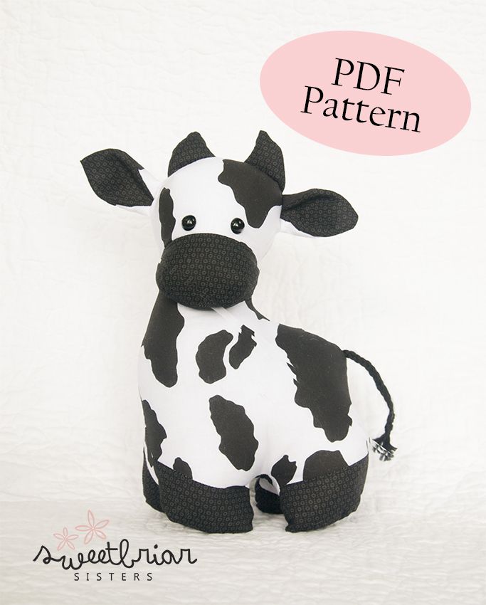 a black and white cow stuffed animal with a pink bubble above it's head