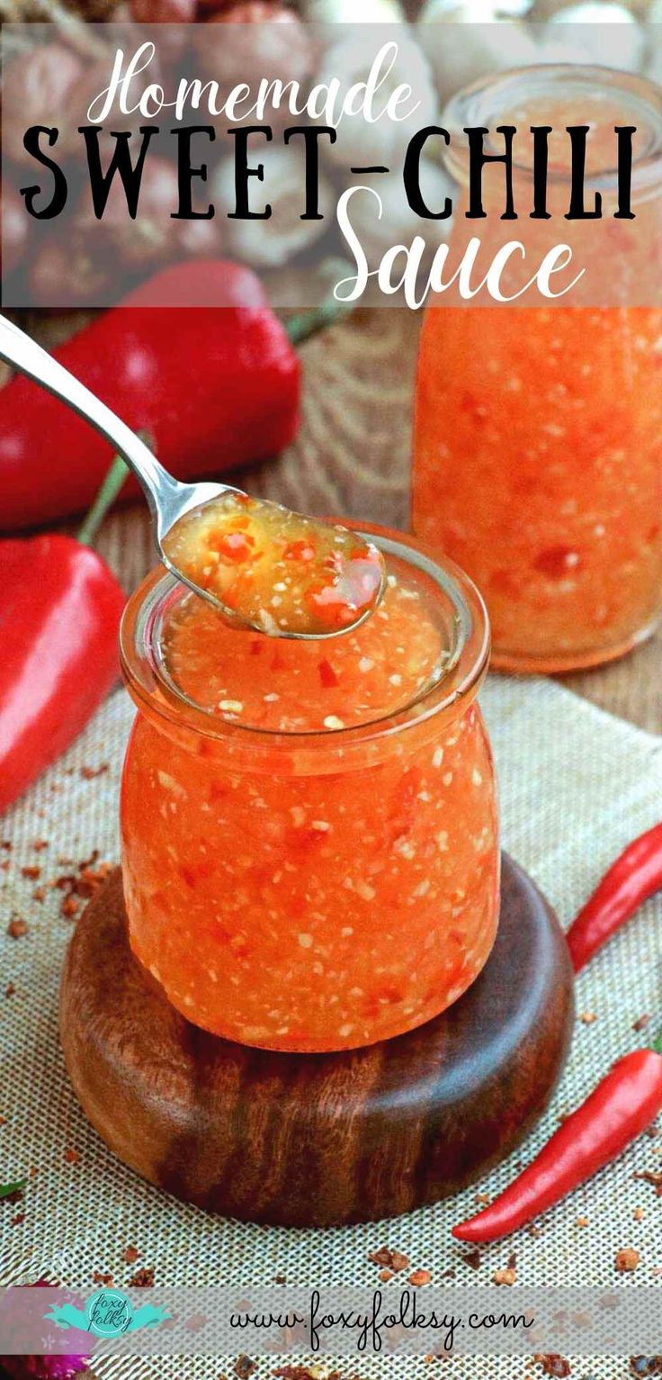 homemade sweet chili sauce in a small glass jar with a spoon on a wooden board