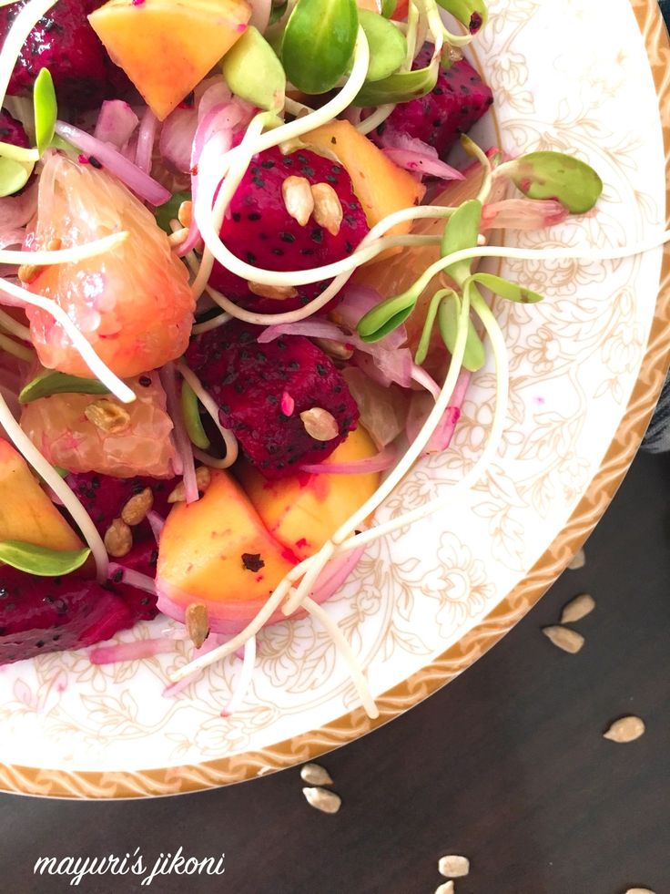 a bowl filled with fruit and vegetables on top of a table